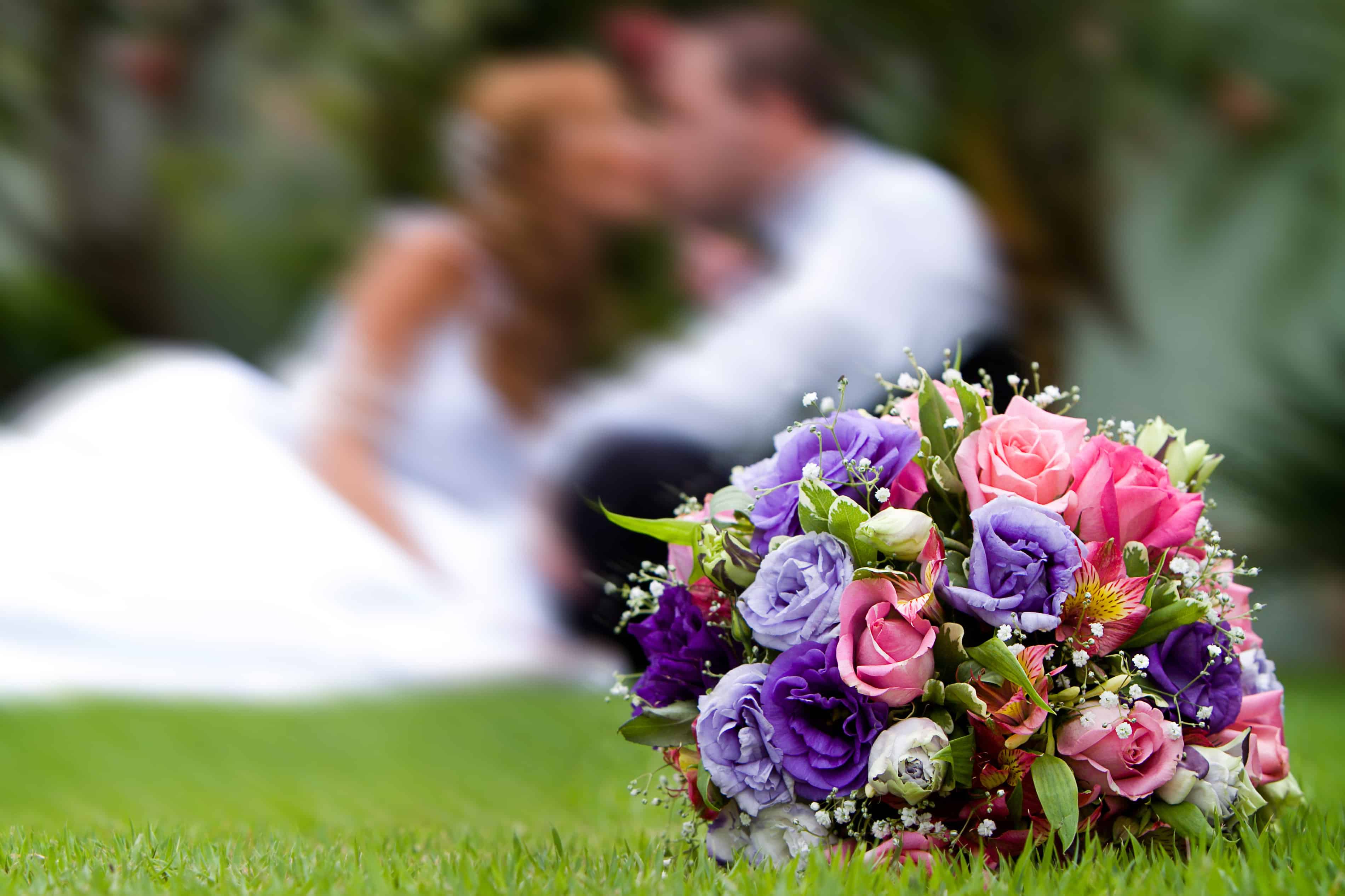 pink and purple flowers with couple in the background