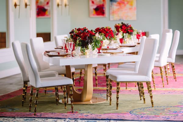 long white table and white chairs with gold accents