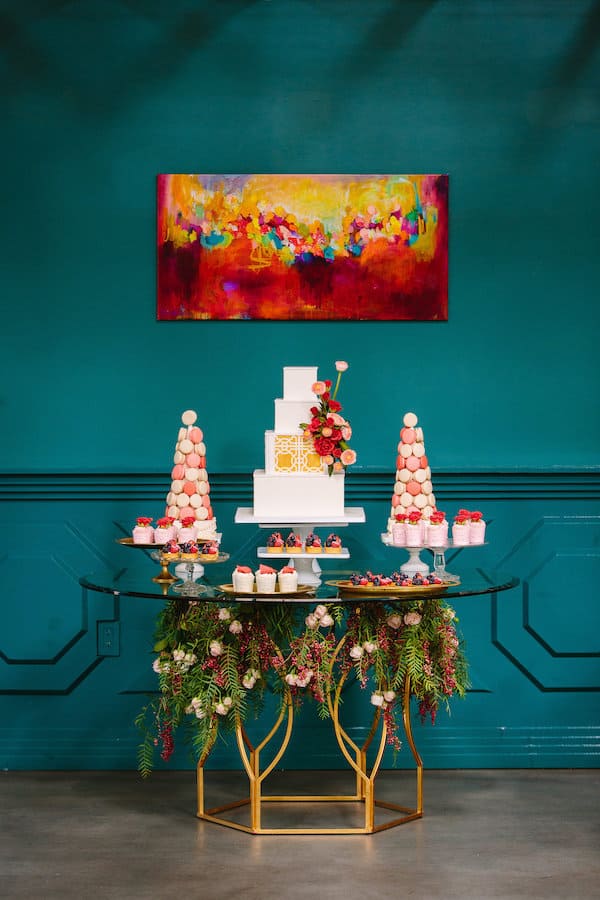 dessert table with colorful food and trimmed by long greens