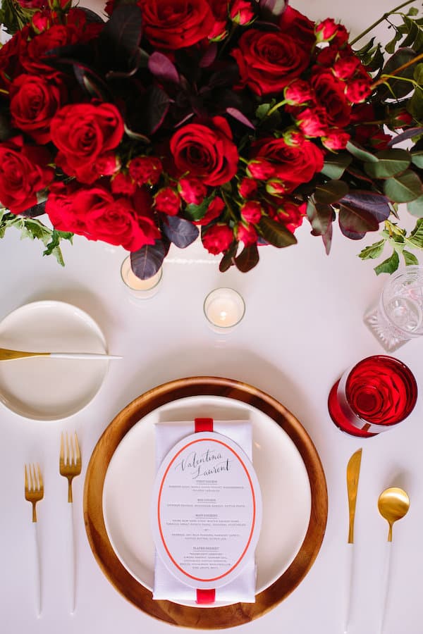 overhead shot of placesetting and red flower centerpiece