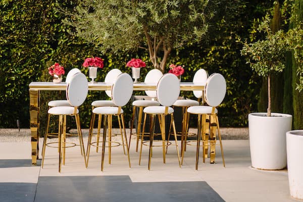 highttop table with red flowers high chairs with gold accents