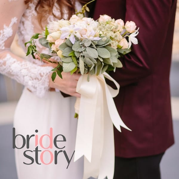 Hollywood the Bride Story Blooms by the Box bride and groom wearing maroon blazer with bride holding floral arrangement