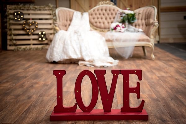 Sign spelling out love with couch and dress in the background