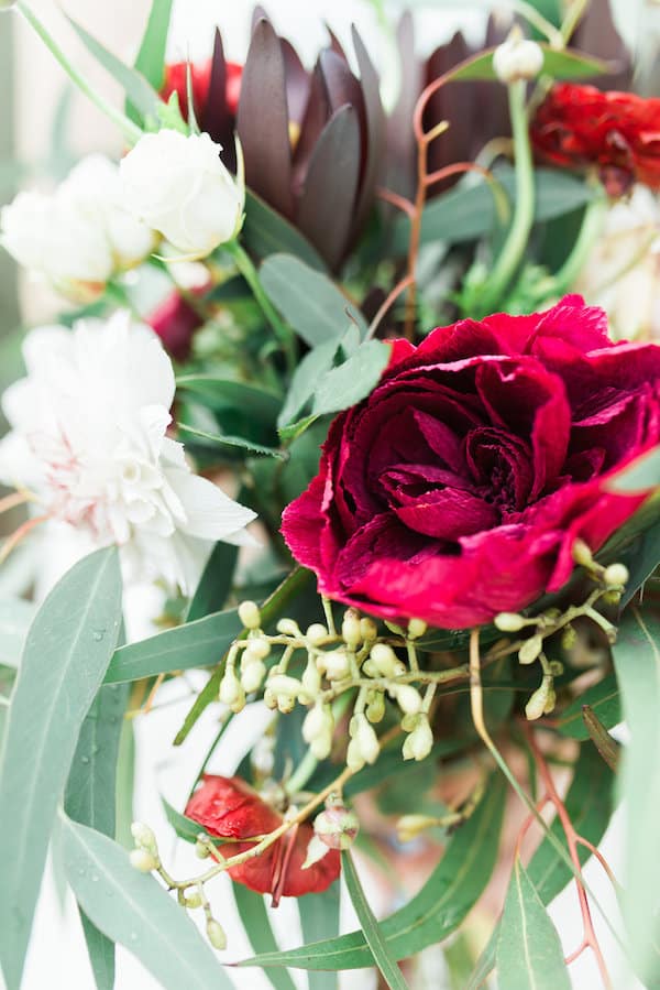 close up of a red flower in a larger floral bouquet