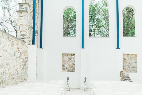 springtime blooms by the box empty wedding chapel with white walls and stone accents