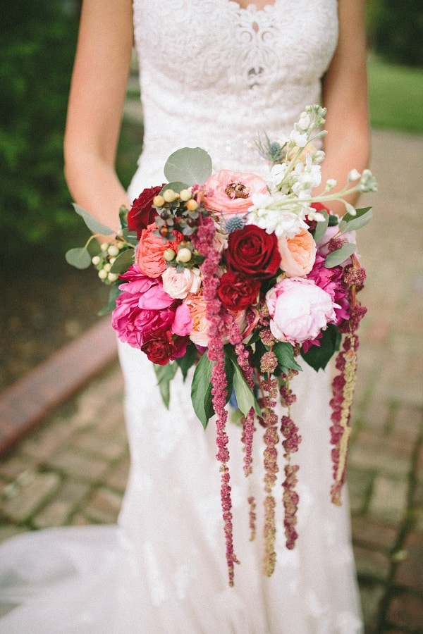 bride in wedding gown holding large floral bouquet