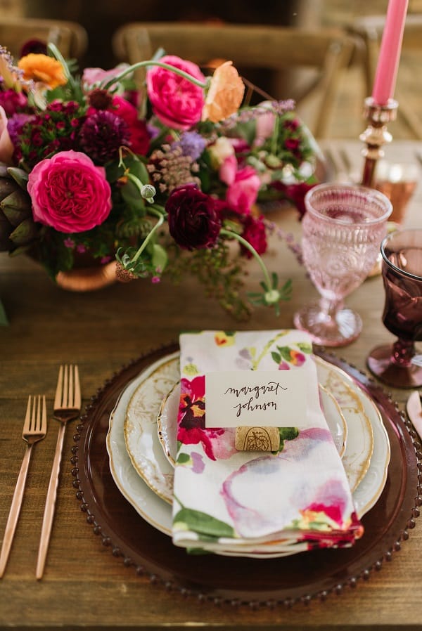 Place setting with a nametag and cork with flowers in the background