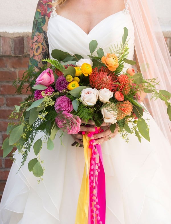 close up of bouquet with orange pink and yellow flowers