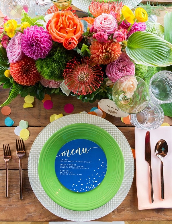 place setting with green plate, glasses and flowers