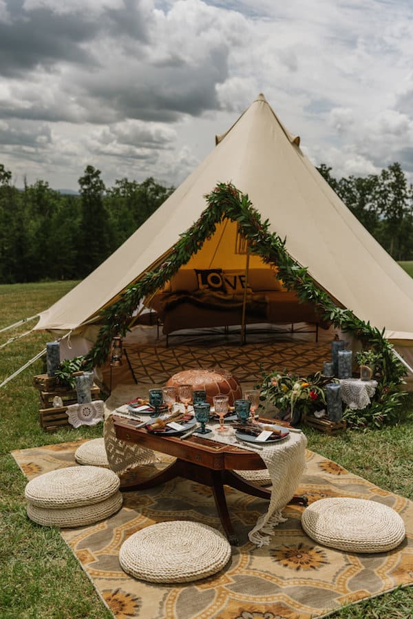 elaborate tent set up with couch and outdoor dining area