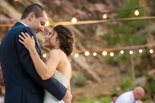 bride and groom dancing outdoors under string lights