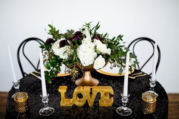 table with black table love sign and white floral arrangement