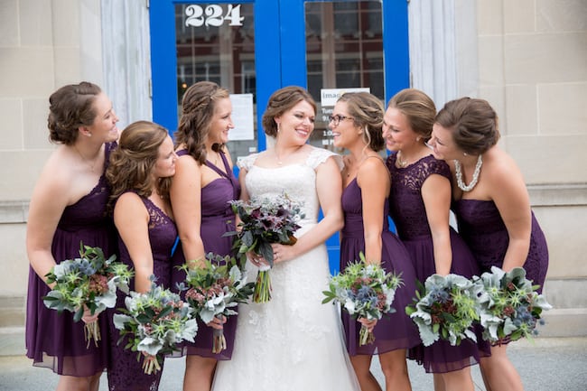 bride and bridesmaids in purple dresses holding bridal bouquets