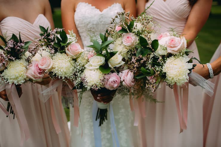 multiple pink and white bridesmaids bouquets with greenery