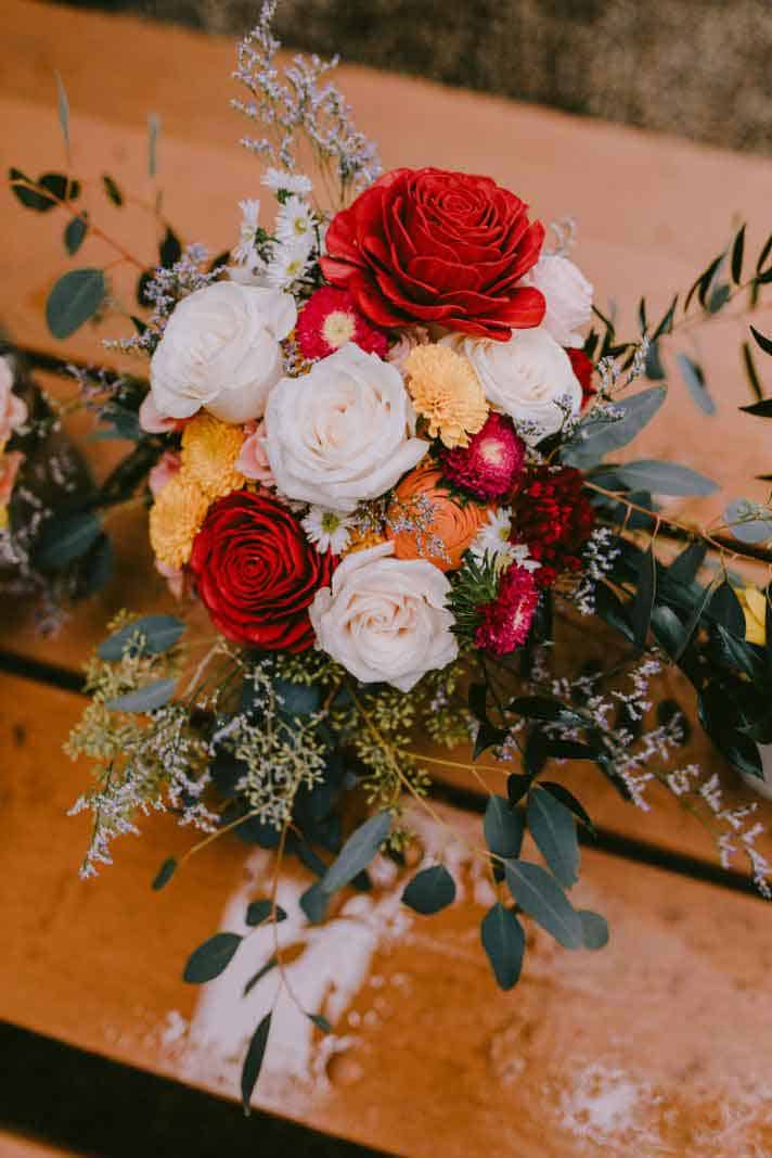 close up of bridal bouquet with red peach and coral flowers