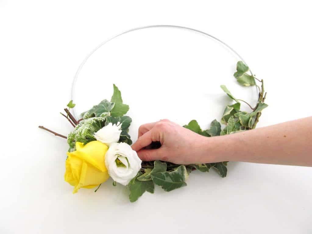 finished DIY floral hoop with white and yellow flowers, greenery