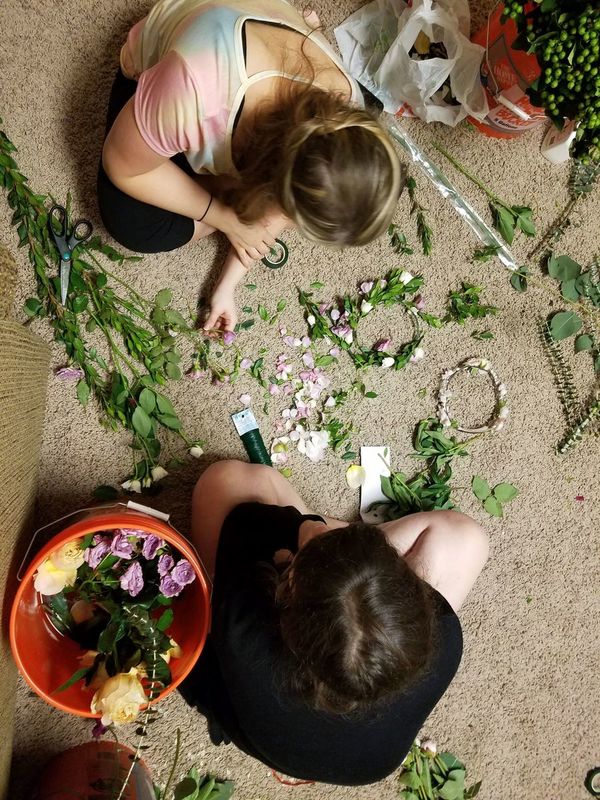 BOHO DIY Wedding Arrangement supplies and two people putting them together from overhead perspective