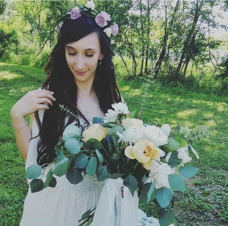 Bride wearing floral crown and holding white and green bouquet