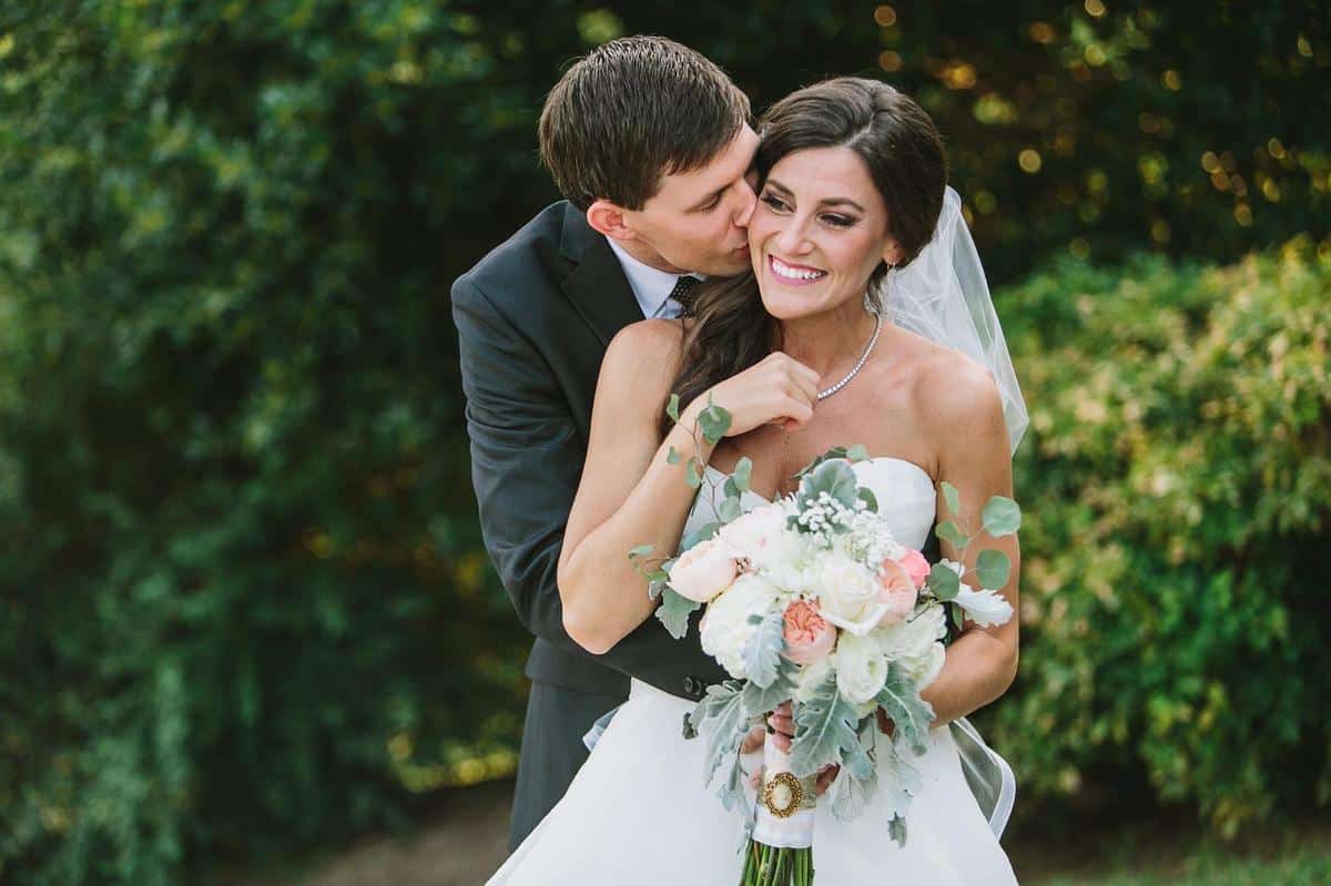 bride and groom embracing

 with bride holding a large bridal bouquet