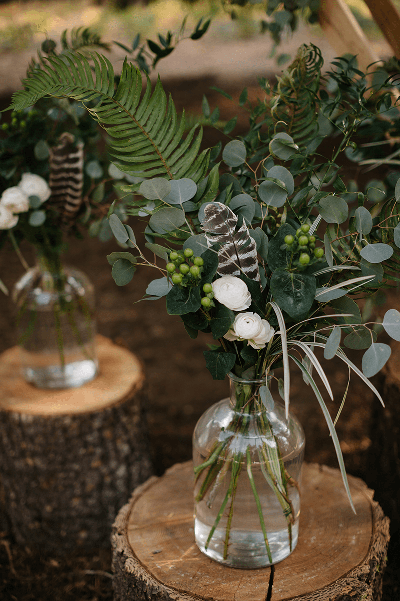 stumps with jars on top them with greens in the jars