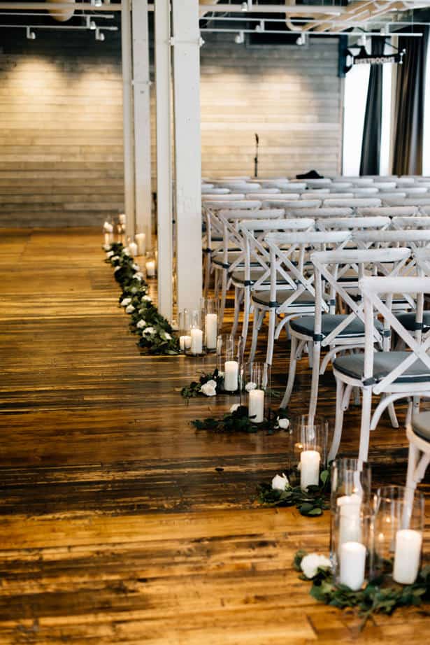 industrial wedding venue seats with candles and wooden floor