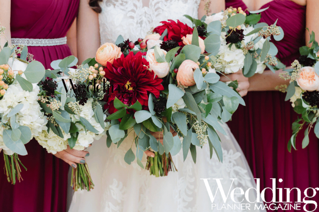 Bride and bridesmaids in crimson dresses with red and pink floral bouquets
