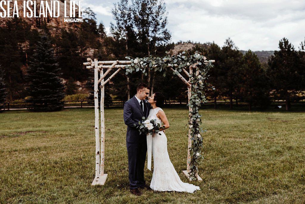 bride and groom under outdoor arch