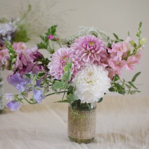 pink and white flowers in mason jars wrapped with burlap