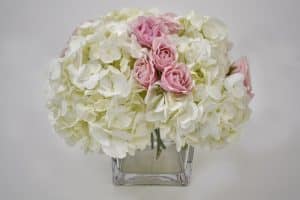 Hydrangeas and pink spray rose in square vase