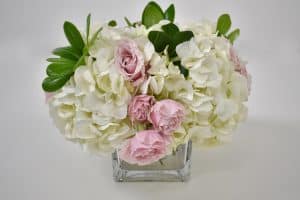 Adding more flowers to DIY hydrangea and rose arrangement