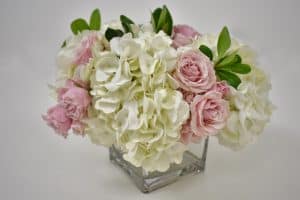 Adding more flowers to DIY hydrangea and rose arrangement