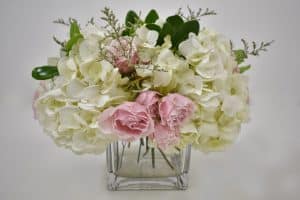 Adding more flowers to DIY hydrangea and rose arrangement