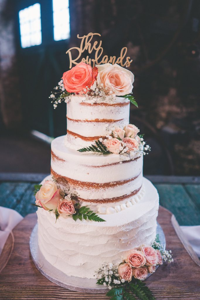 Cake decorated with flowers and sign that says the Rowlands