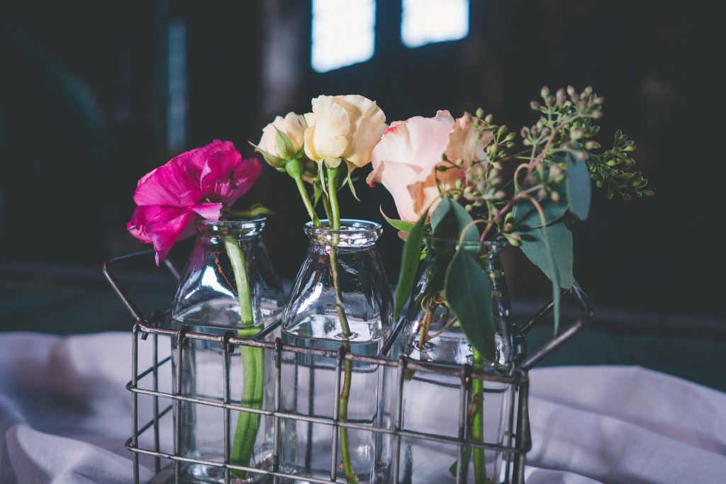 Red, pink and white flowers in bottle jars