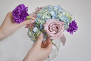 Pink and purple rose faith with blue hydrangeas in a mason jar