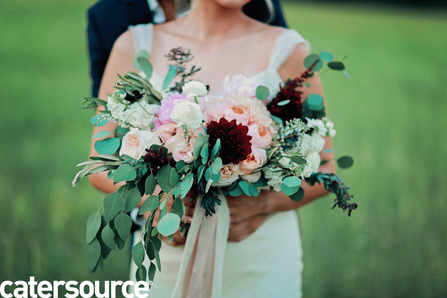 Bride holding pink, white and red flowers