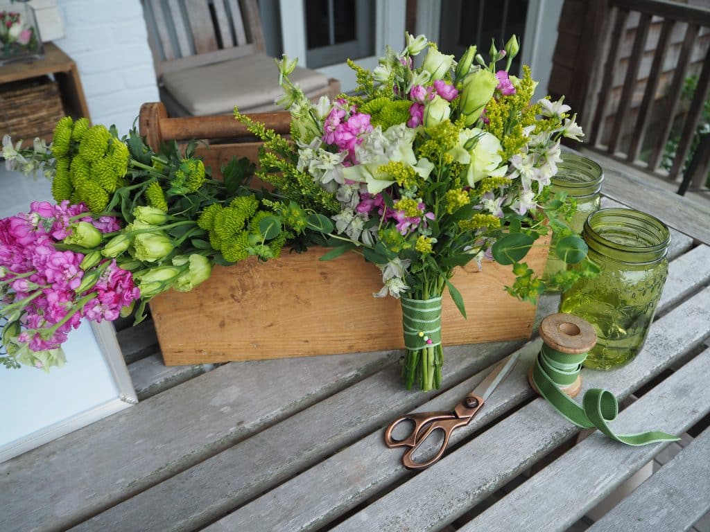 Finished bouquet with scissors, ribbon, mason jars and flowers in a wooden box