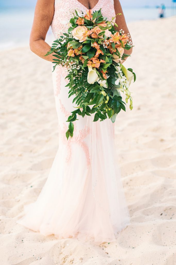 Woman holding flower bouquet on a beach