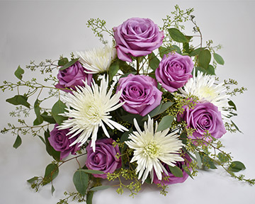 white football mums with purple flowers with seeded eucalyptus stems in floral foam