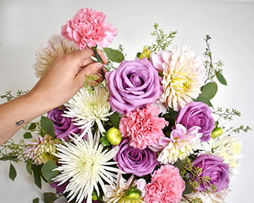 Adding pink carnations to the arrangement