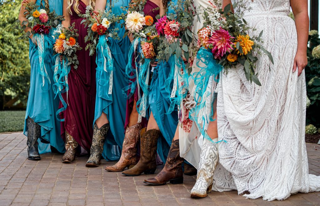 Bride and Bridesmaids showing cowboy boots and multocolored flowers