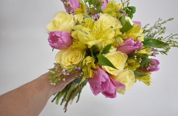 Yellow roses and purple tulips with greens