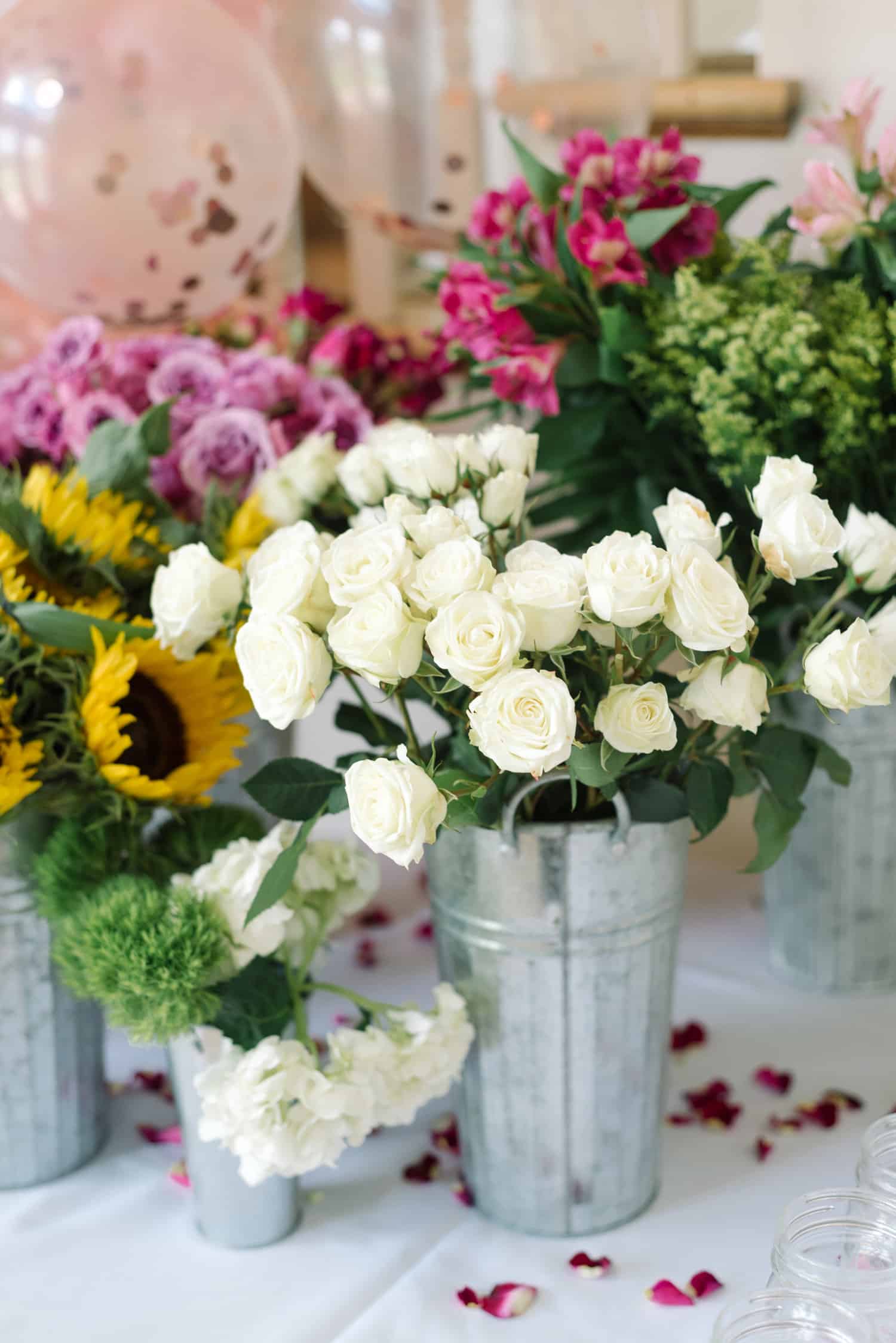 Various color flowers in holders for bridal flower bar