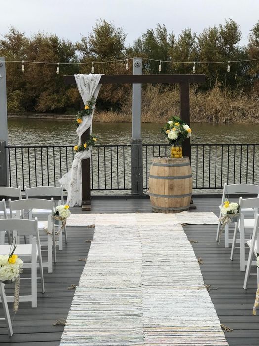 Styled Wedding chairs on either side of aisle with water background