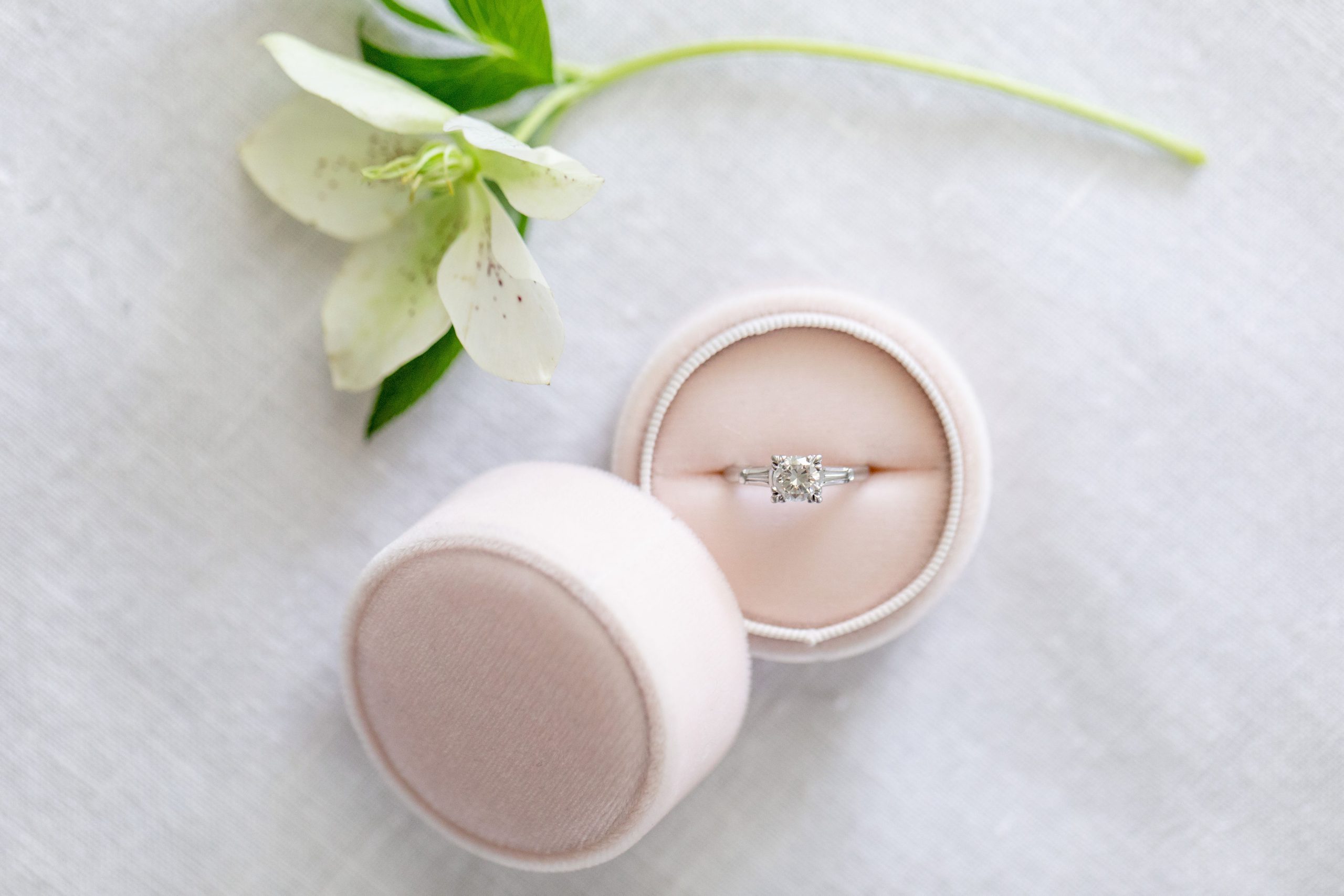 Wedding ring in a pink box with a white flower