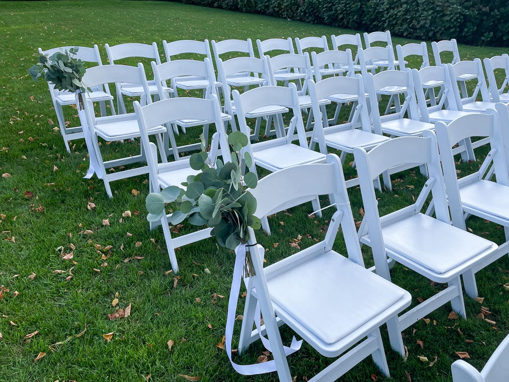 wedding chairs decorated with eucalyptus