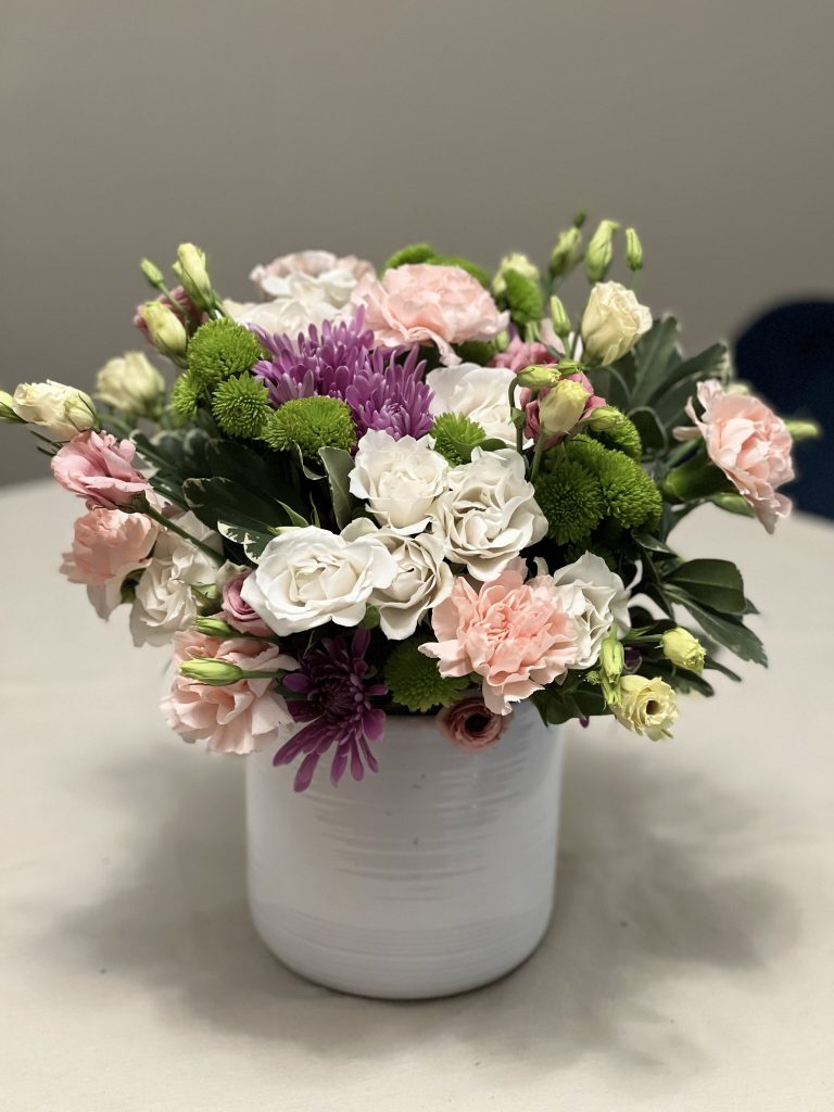 white vase with flowers in varying colors