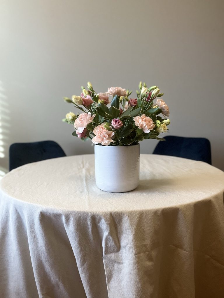 vase with greenery, carnations, and lisianthus