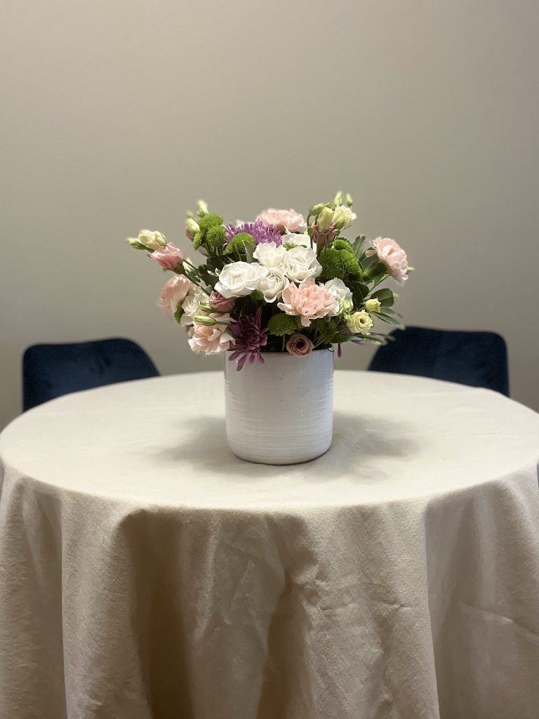 vase with greenery, carnations, lisianthus, and chyrsanthemums, and spray roses