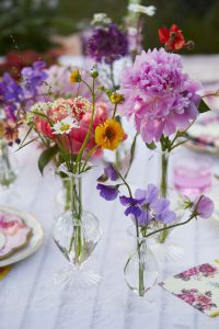 Make the vases stand out with a color palette of purple, orange, pink, yellow flowers.